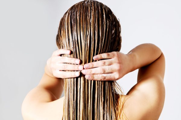Woman applying hair conditioner. Isolated on white. Blond woman applying hair conditioner. Isolated on white.